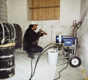 Mann knieend beim Hydrophobieren des Mauerwerk