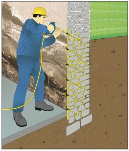 Brugger AG Mann Steht mit Gelbem Helm und blauer Arbeitskleidung vor Kellerwand Mauertrocknung innerlich von Innen